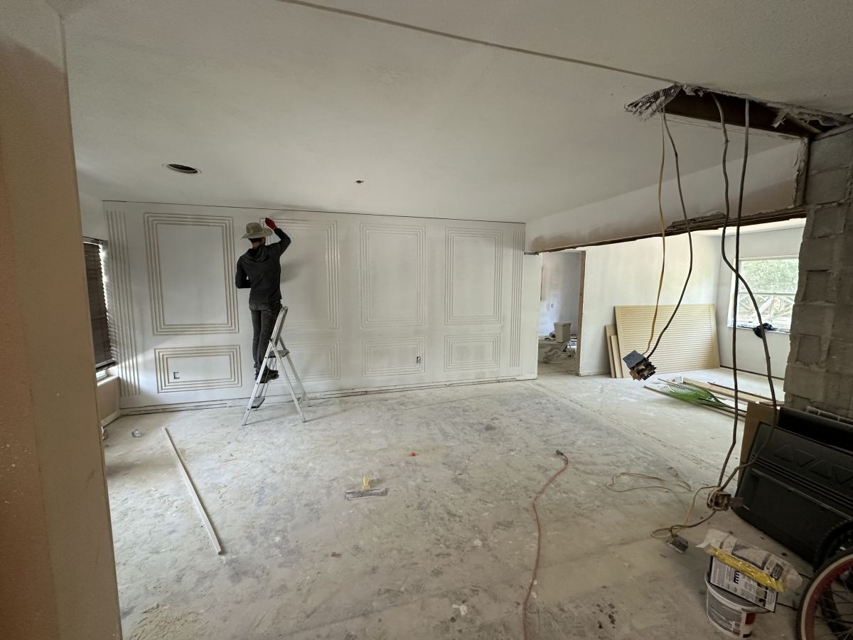 Worker painting the interior of a home under renovation